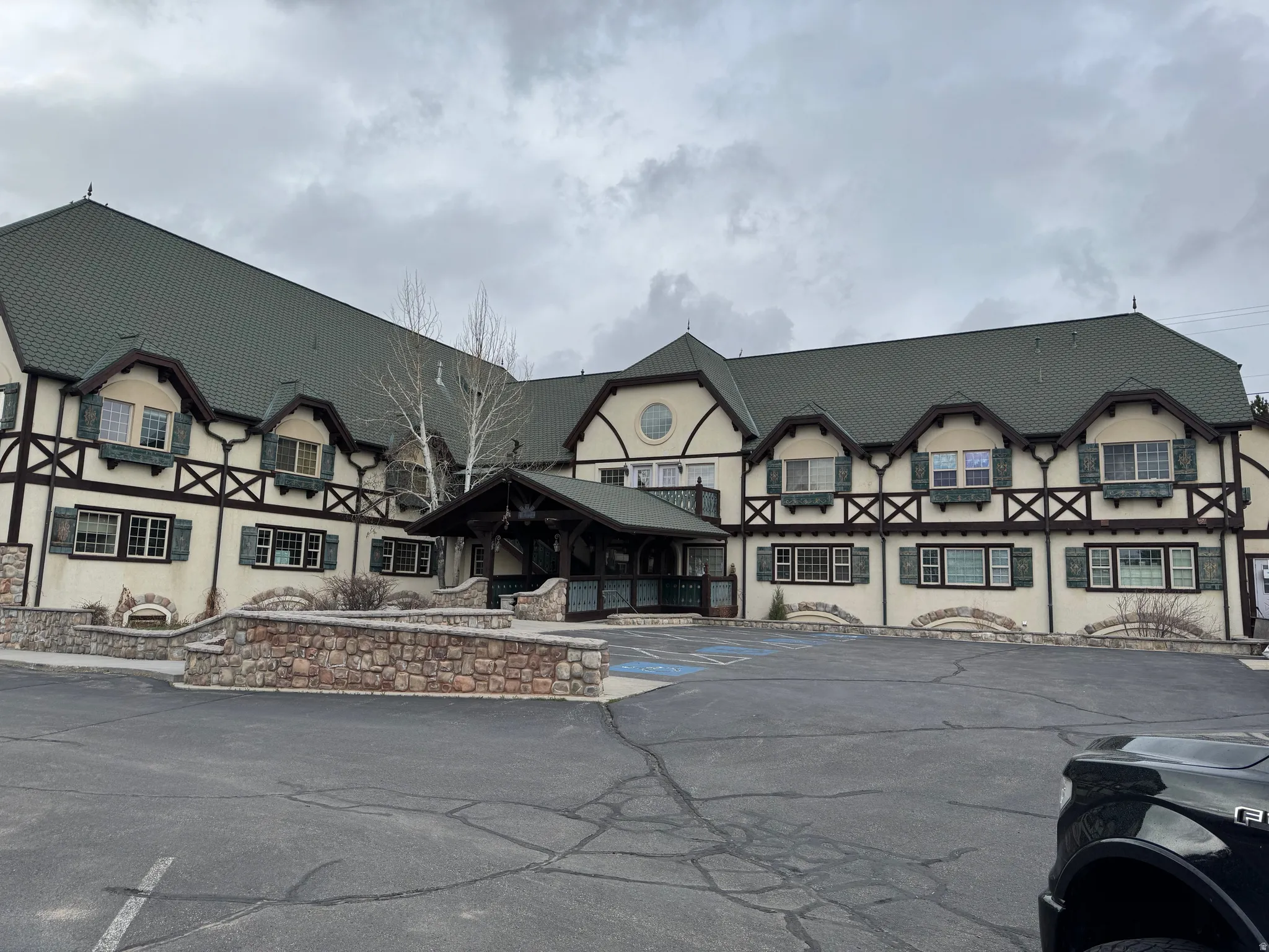 Tudor-style building featuring dark-trimmed gables and a prominent covered entryway