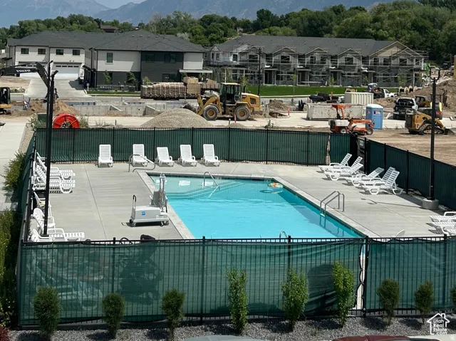Outdoor swimming pool with concrete decking, perimeter fencing, and lounge chairs