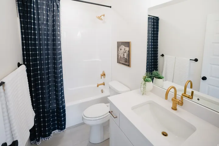 Bathroom featuring a white vanity with integrated sink, gold-finish faucet, and coordinating hardware