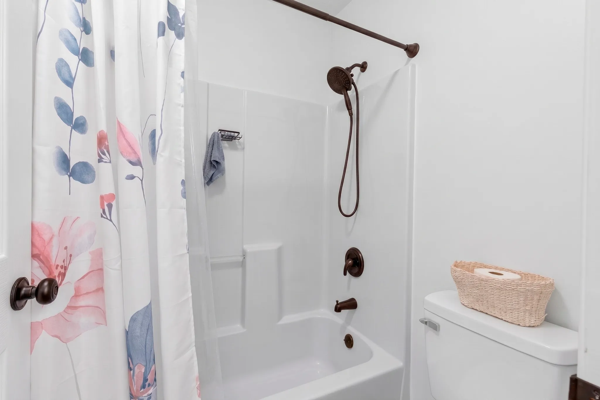 Bathtub with a shower combination featuring a bronze showerhead and faucet