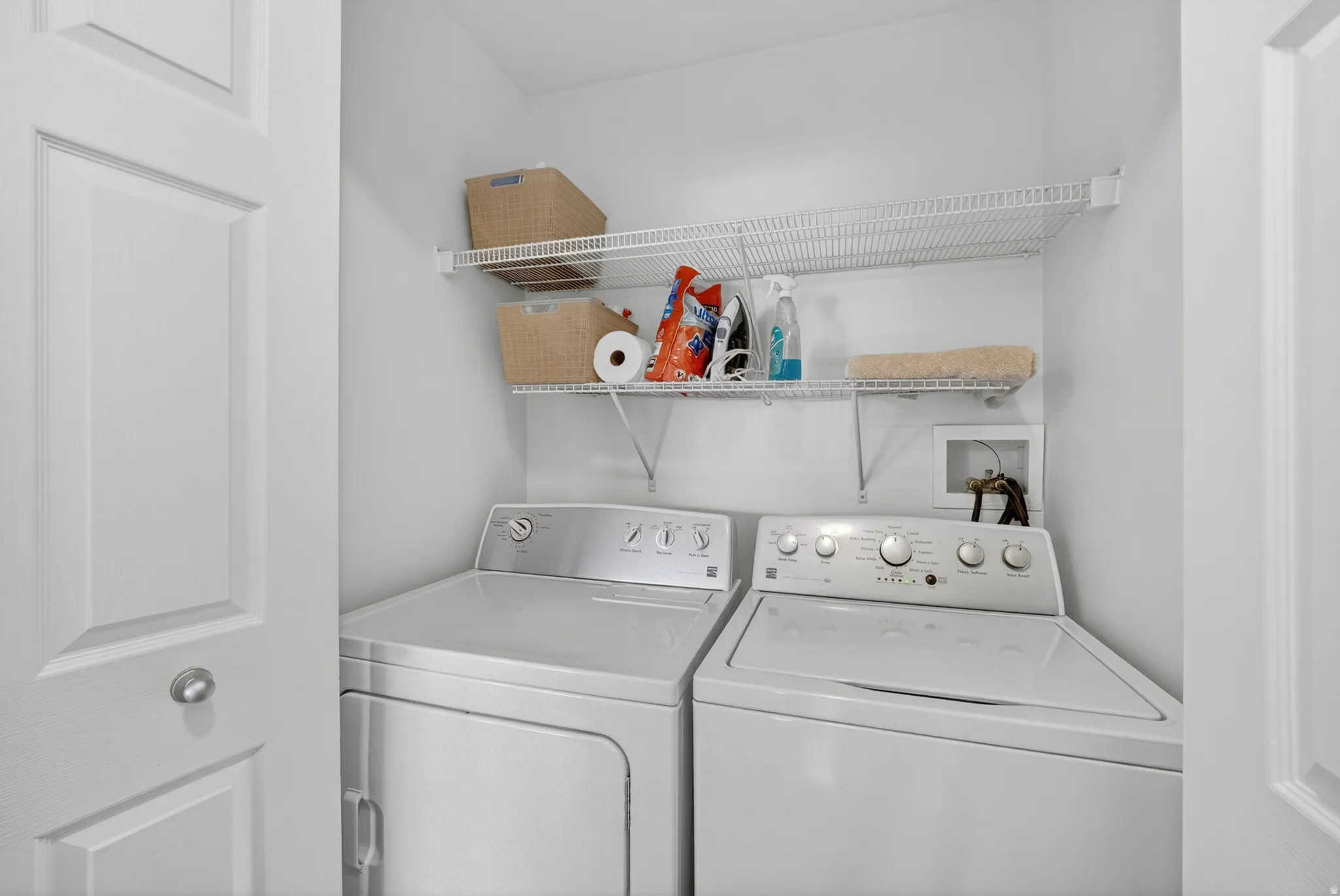 Dedicated laundry area featuring wire shelving, a washer, and a dryer