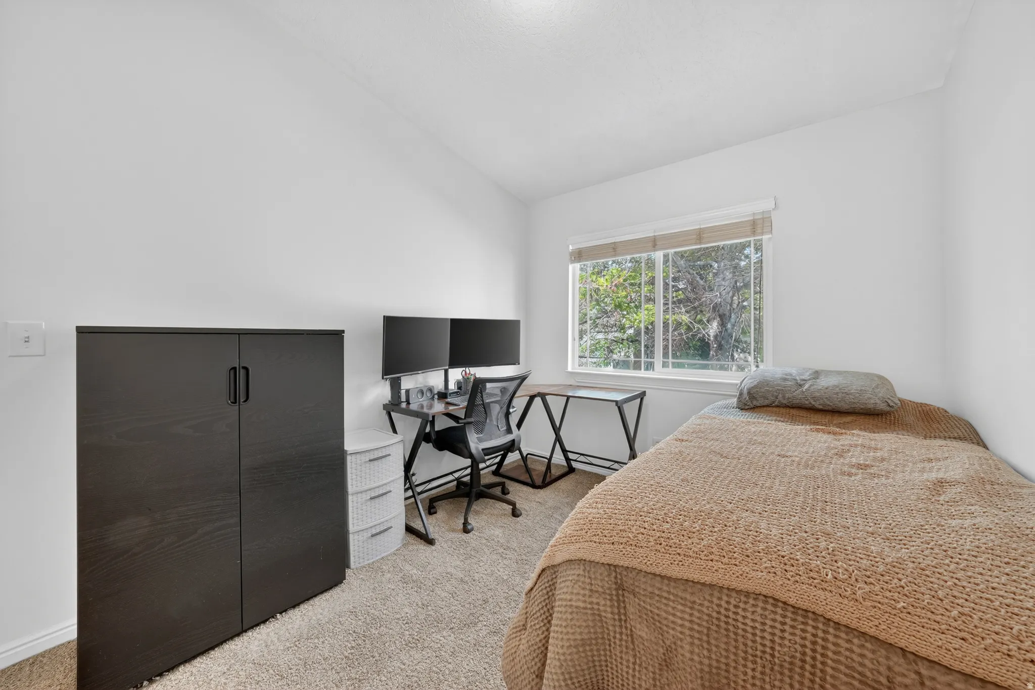 Bright bedroom with a large window and light-colored walls