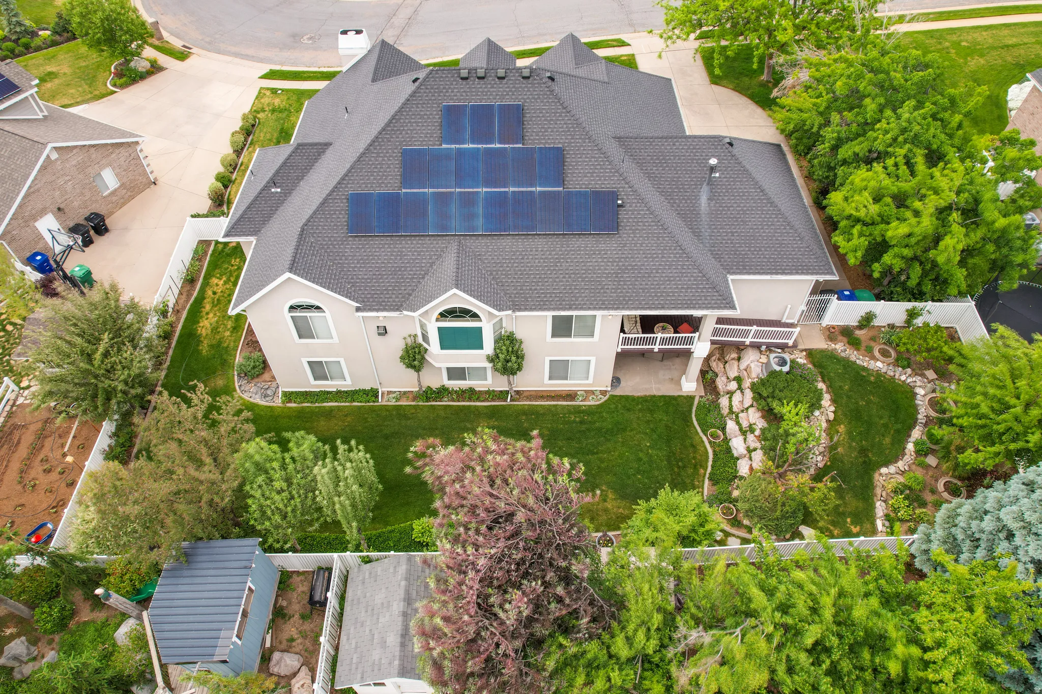 Two-story property featuring a multi-gabled roofline and multiple solar panel arrays