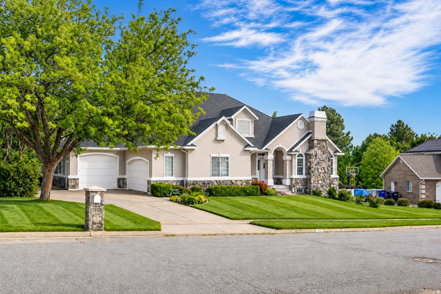 Stucco exterior with stone accents and a multi-car garage