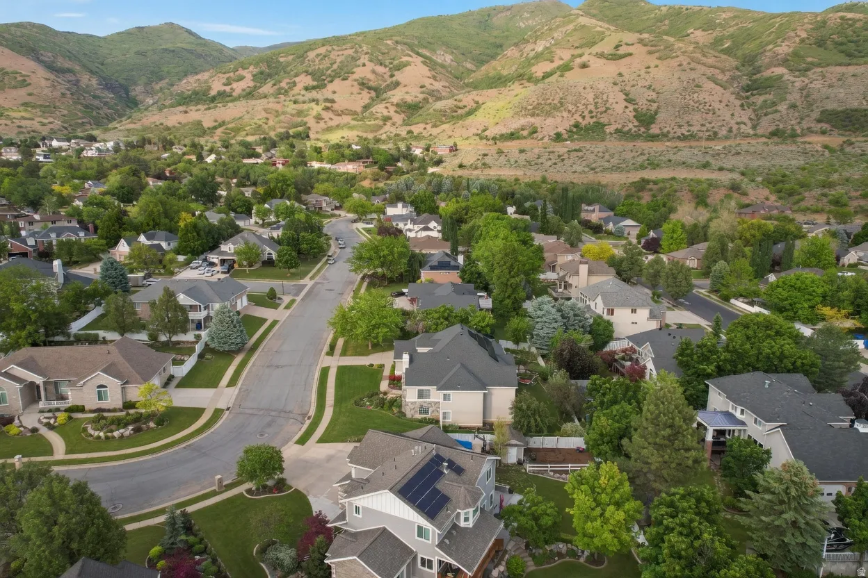 Residential neighborhood with mature trees and mountain backdrop