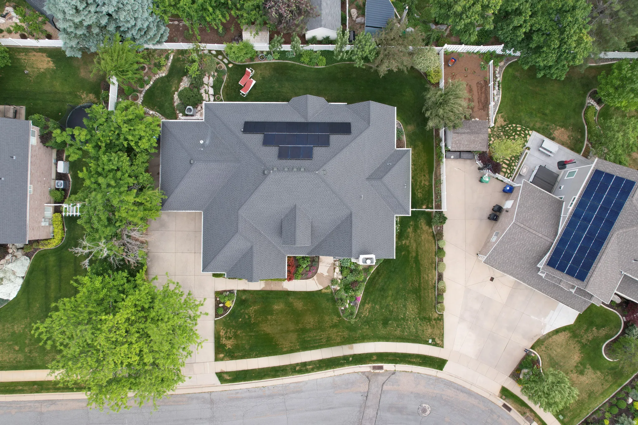 Expansive property featuring a multi-gabled roofline, solar panel array, and a concrete driveway