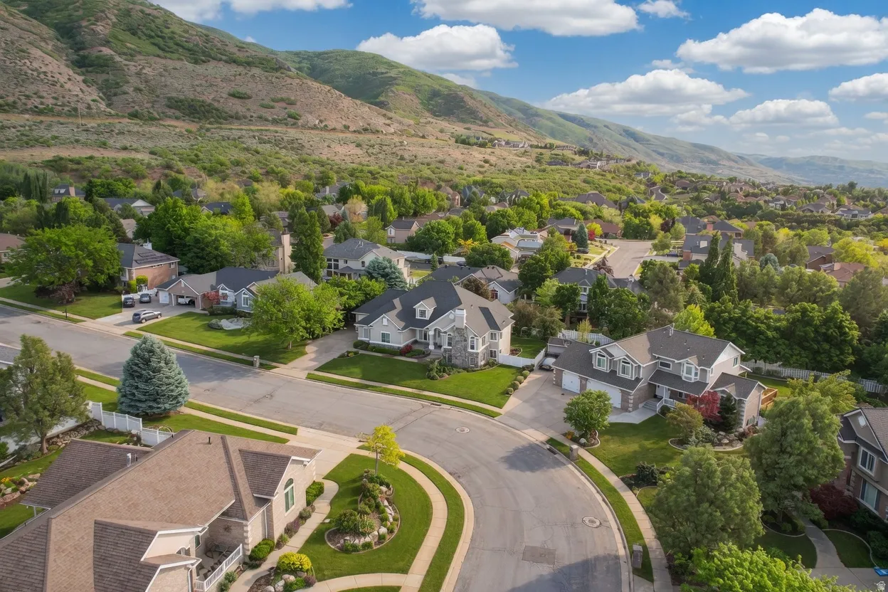 Residential neighborhood setting with mature landscaping, surrounded by expansive natural hillsides