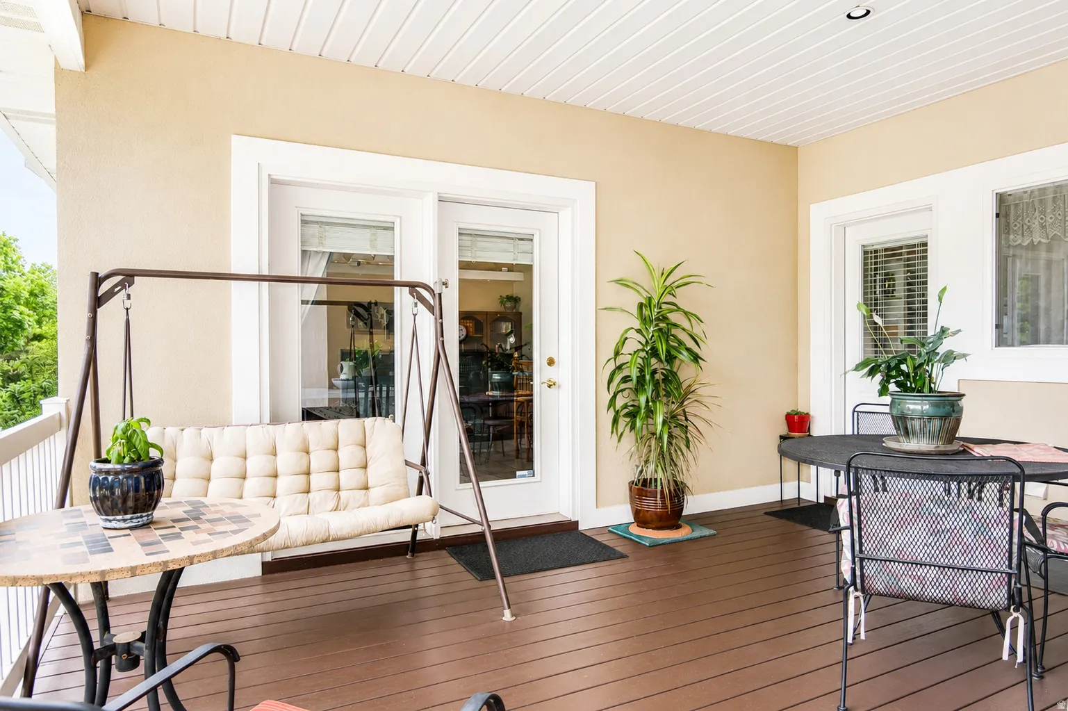 Covered outdoor deck with rich brown wood-finish flooring