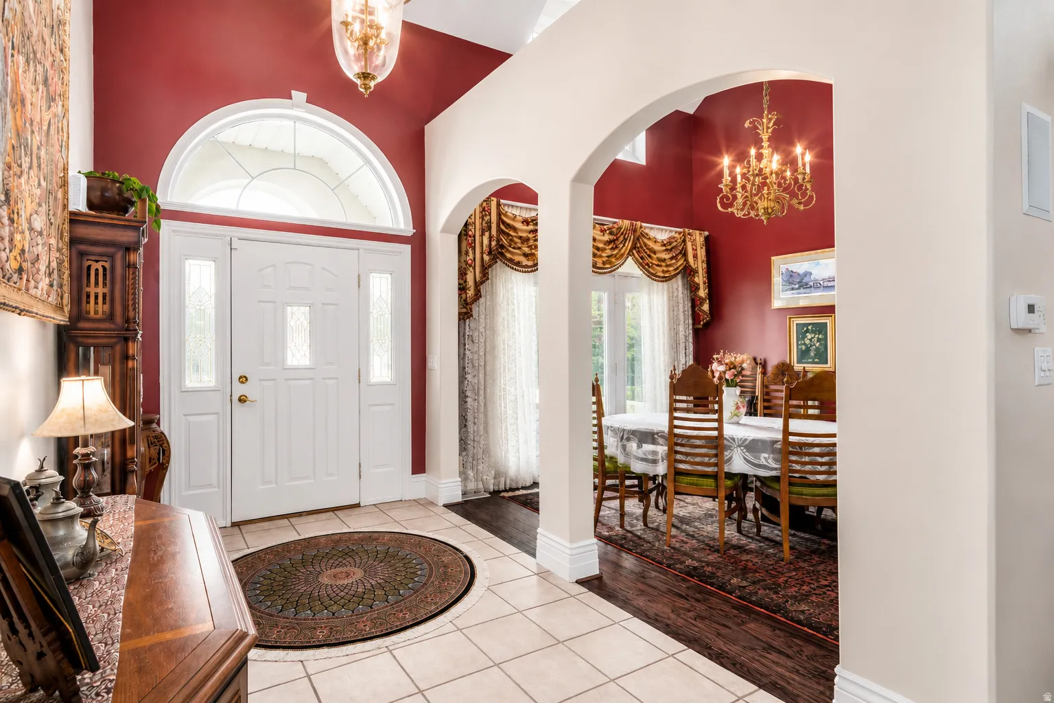 Grand entryway featuring a double door with decorative glass inserts and a transom window