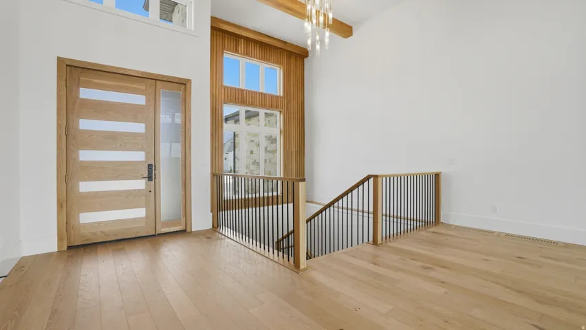 Entryway with light wood-finish flooring and a contemporary wood door featuring horizontal frosted glass panels