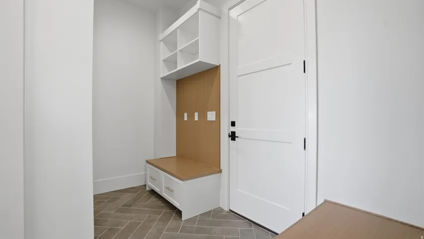 Built-in mudroom bench with natural wood-finish backing, upper cubbies, and lower cabinet storage