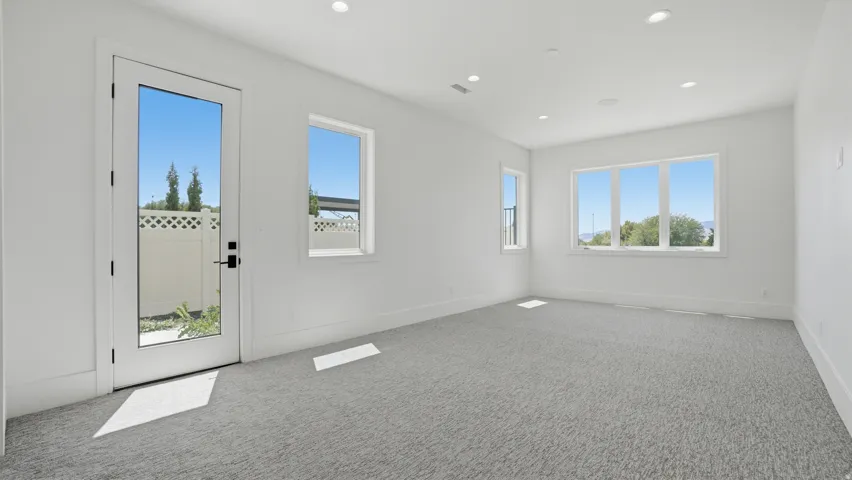 Bright room featuring light gray carpeting and white walls