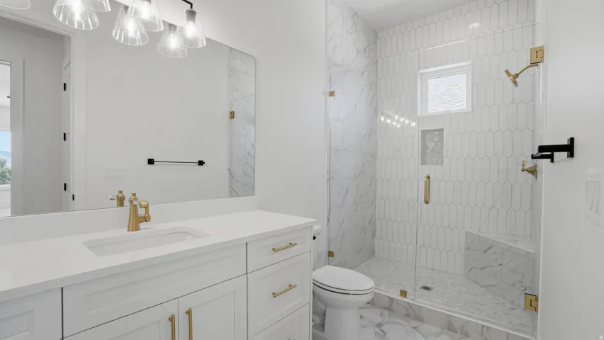 Spacious bathroom featuring a frameless glass shower enclosure with a built-in bench and a window