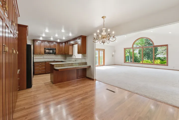 Spacious kitchen featuring wood-finish flooring, recessed lighting, and ample cabinetry