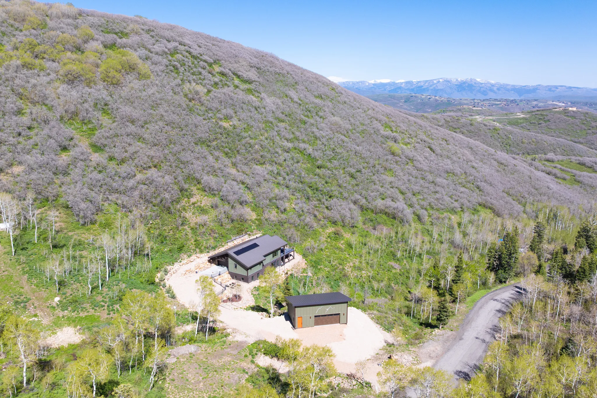 Aerial view of property and surrounding area with a mountain backdrop