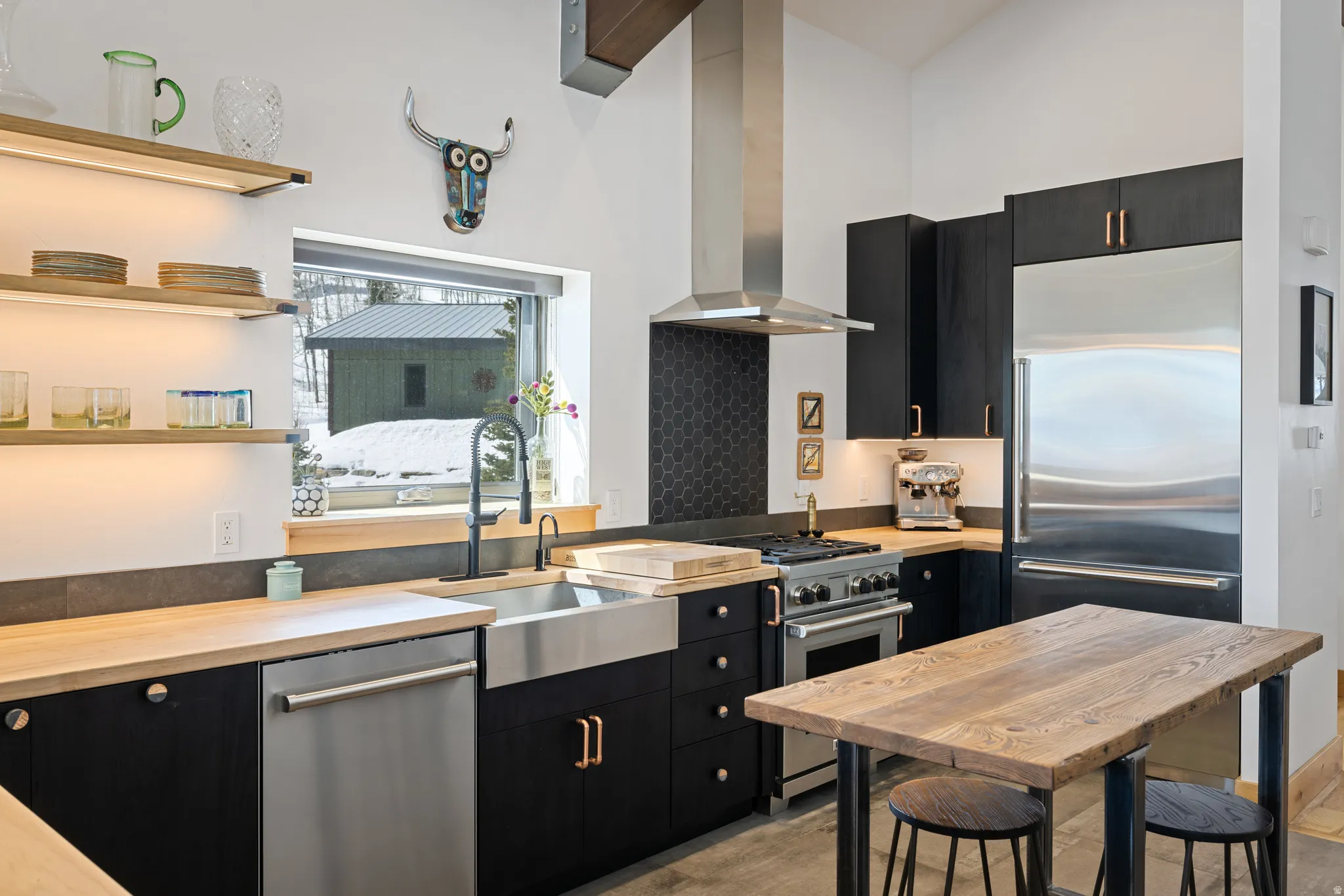 Kitchen with dark cabinetry, high end appliances, wooden counters, modern cabinets, and open shelves