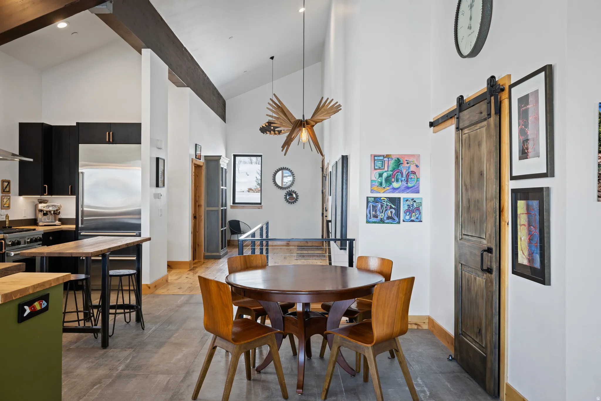 Dining space with a barn door and lofted ceiling