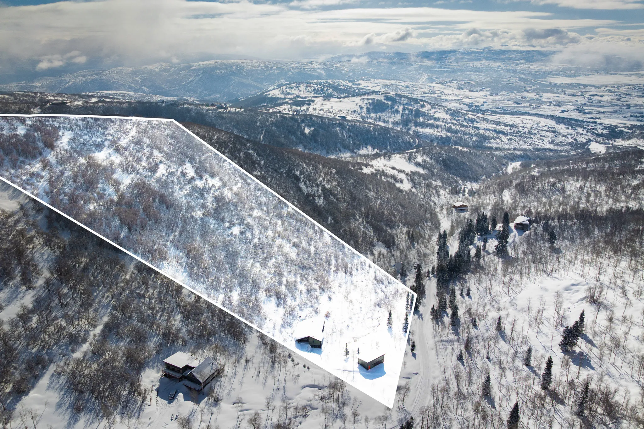 Snowy aerial view featuring a mountain view and property boundaries highlighted
