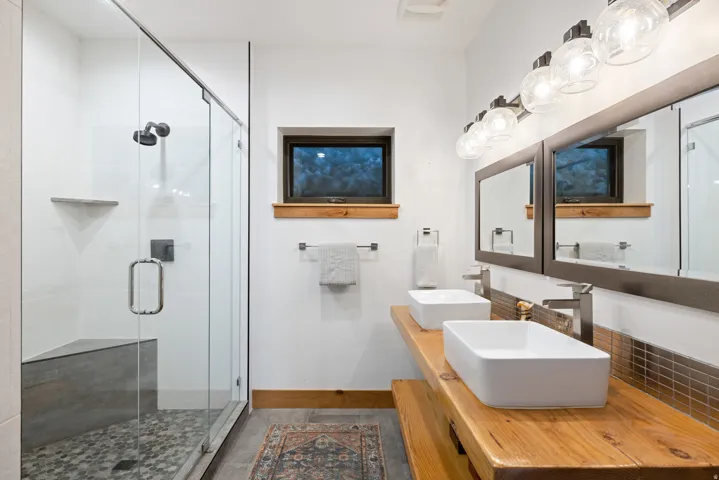 Full bath featuring a shower stall and double vanity