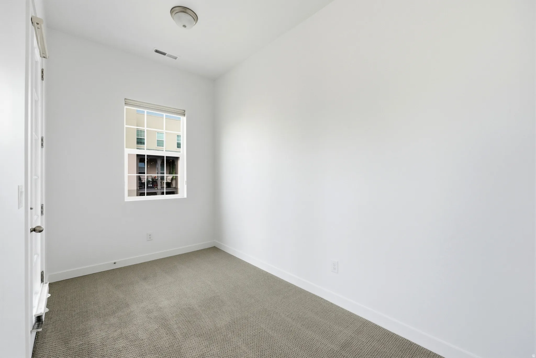 Carpeted empty room featuring baseboards