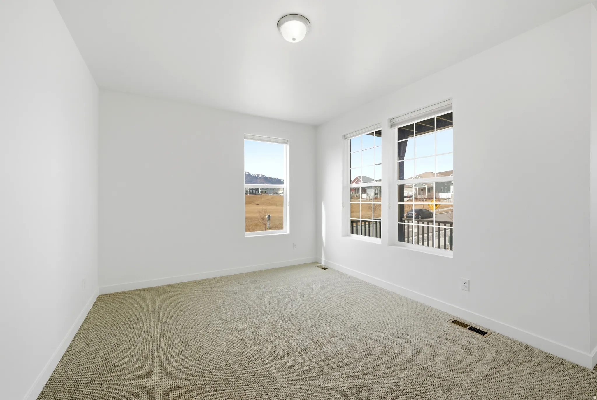 Empty room with light carpet and baseboards