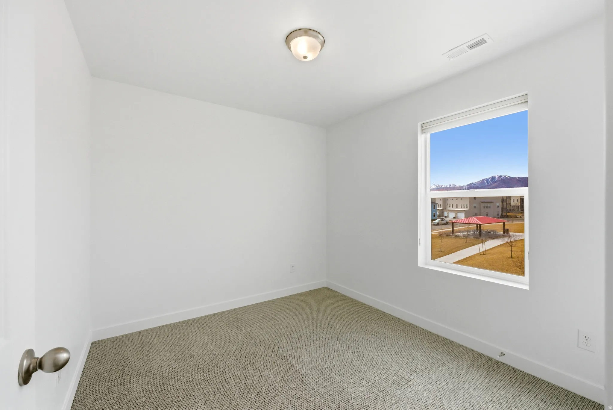 Empty room with light carpet and baseboards