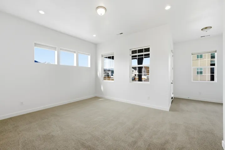 Empty room featuring light carpet and recessed lighting