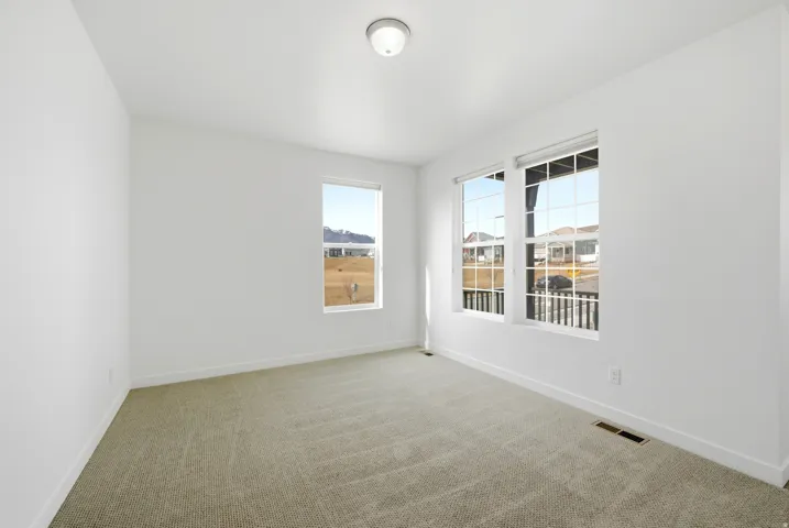 Empty room with light carpet and baseboards