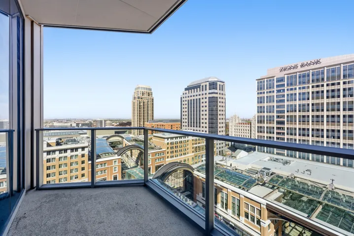 Private balcony featuring glass railings and urban skyline views