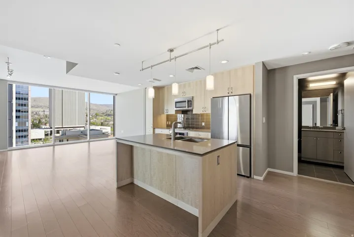 Open-concept living space featuring wood-finish flooring and expansive floor-to-ceiling windows