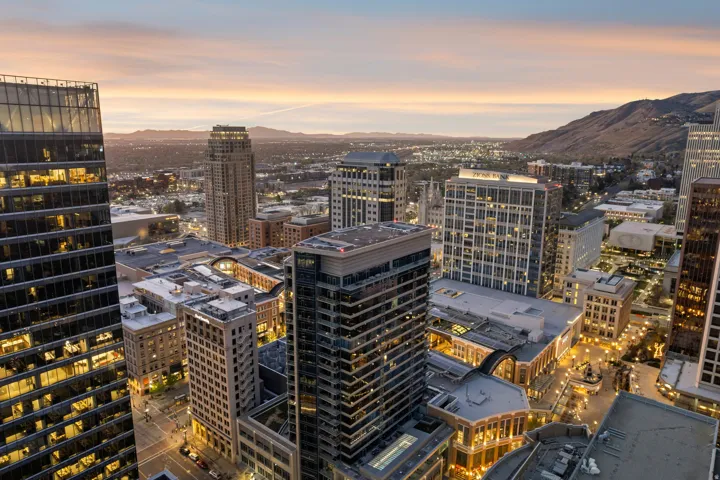 Expansive cityscape featuring modern high-rise buildings and mountain backdrop