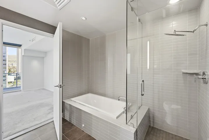 Bathroom featuring a built-in soaking tub and a glass-enclosed shower with a rainfall showerhead