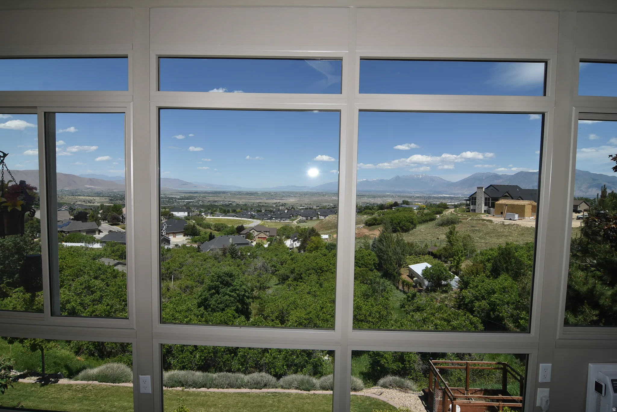 Expansive multi-pane window system with white framing, offering broad outdoor scenery