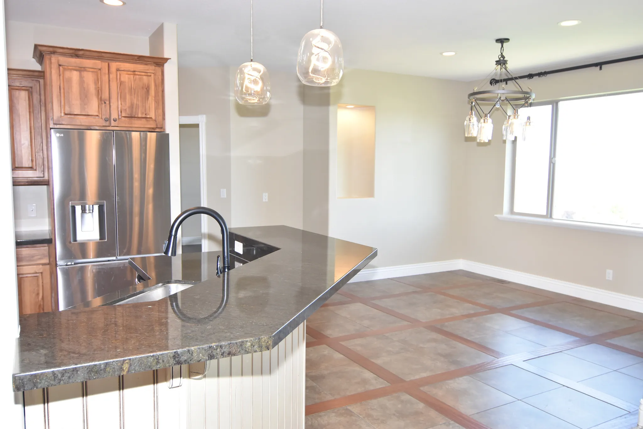 Kitchen island featuring a stainless steel undermount sink and a matte black faucet