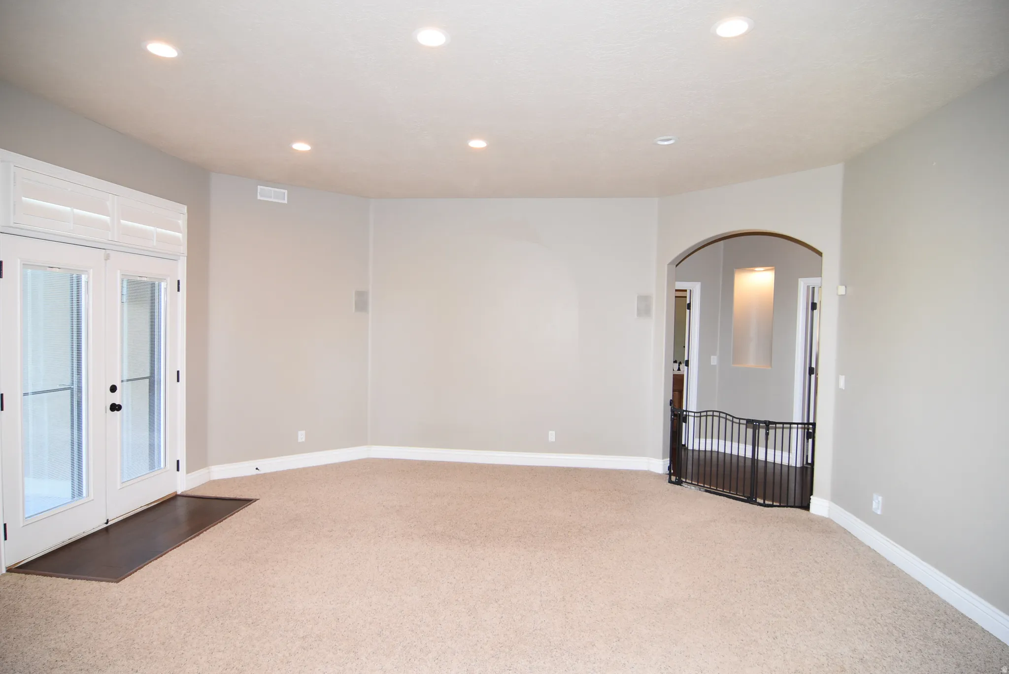 Spacious room featuring neutral carpeting and light gray walls
