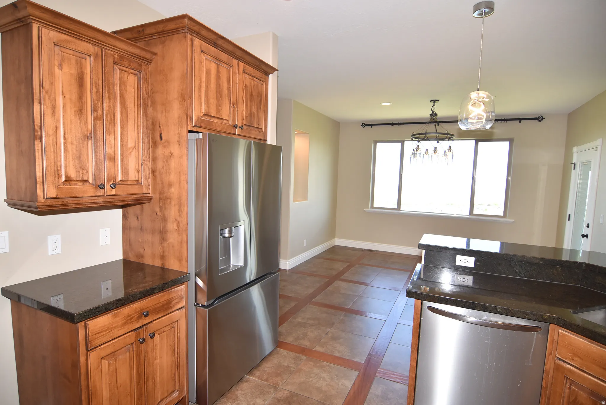 Kitchen space featuring wood cabinetry and dark countertops