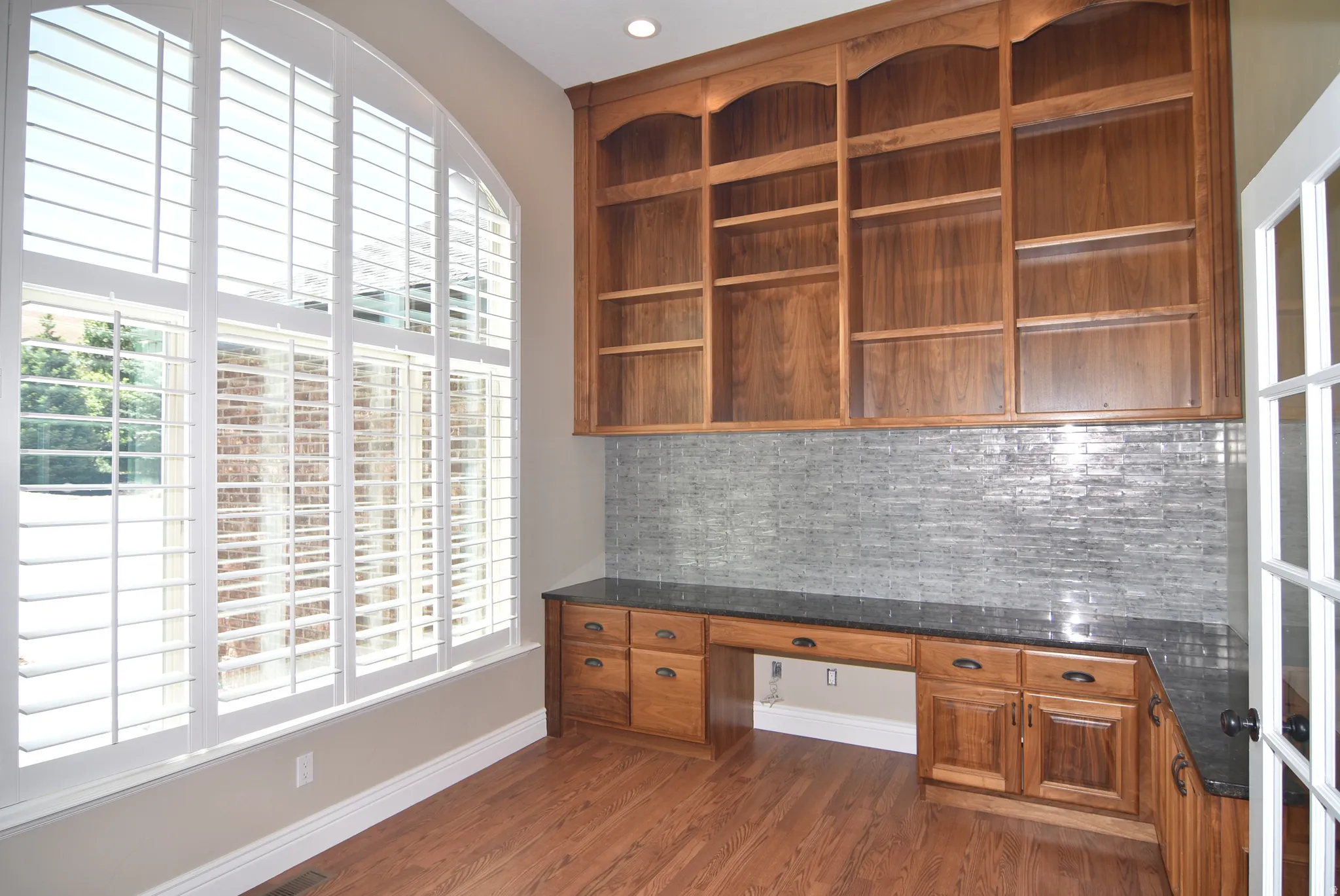 Built-in wood cabinetry with integrated shelving and a dark countertop