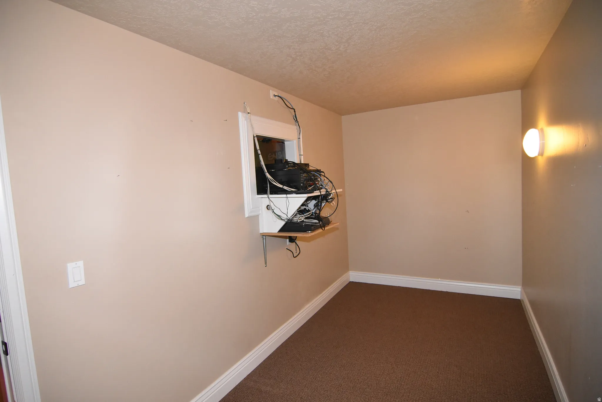 Room featuring neutral wall paint, white baseboards, and brown textured carpeting