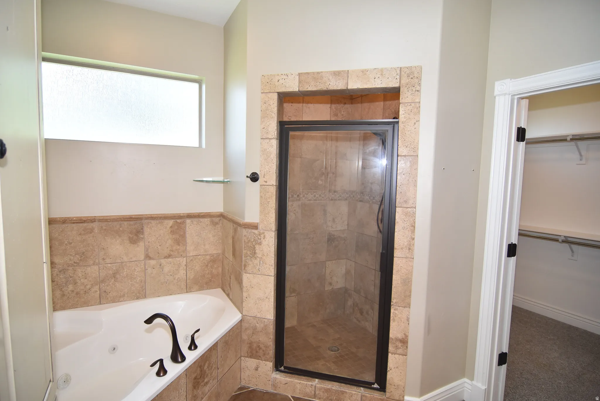 Owner's Tiled shower enclosure with dark-framed glass door, integrated built-in shelving, and contrasting baseboard trim