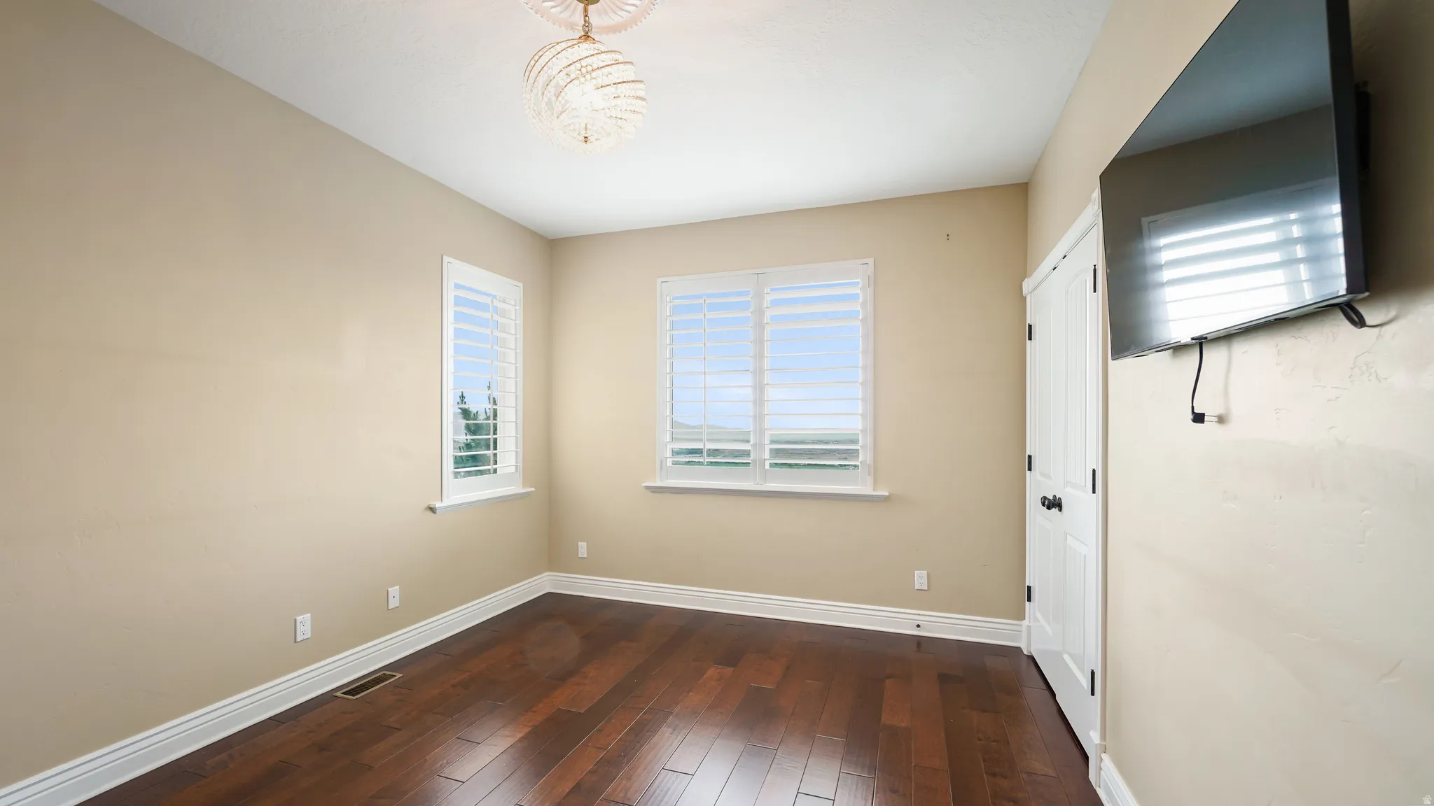 Room featuring rich wood-finish flooring and neutral wall tones