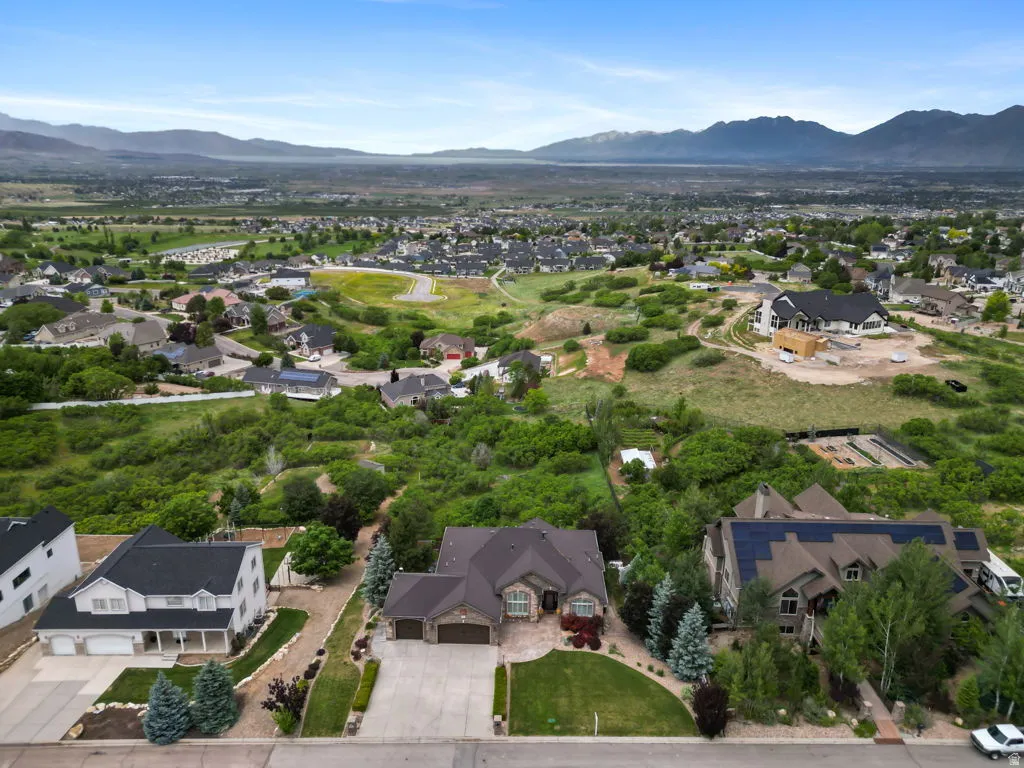 Expansive residential area featuring a variety of architectural styles, mature landscaping, and mountainous terrain in the distance