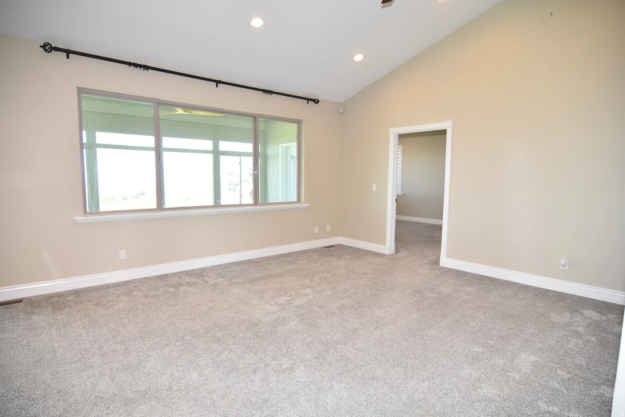 Spacious room with vaulted ceilings and recessed lighting