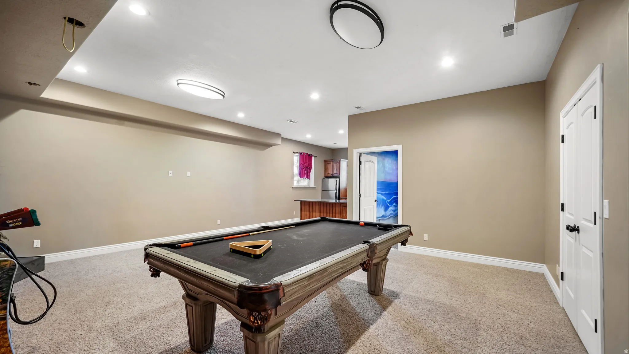 Expansive recreation space featuring recessed lighting, neutral wall tones, and light-toned carpeting