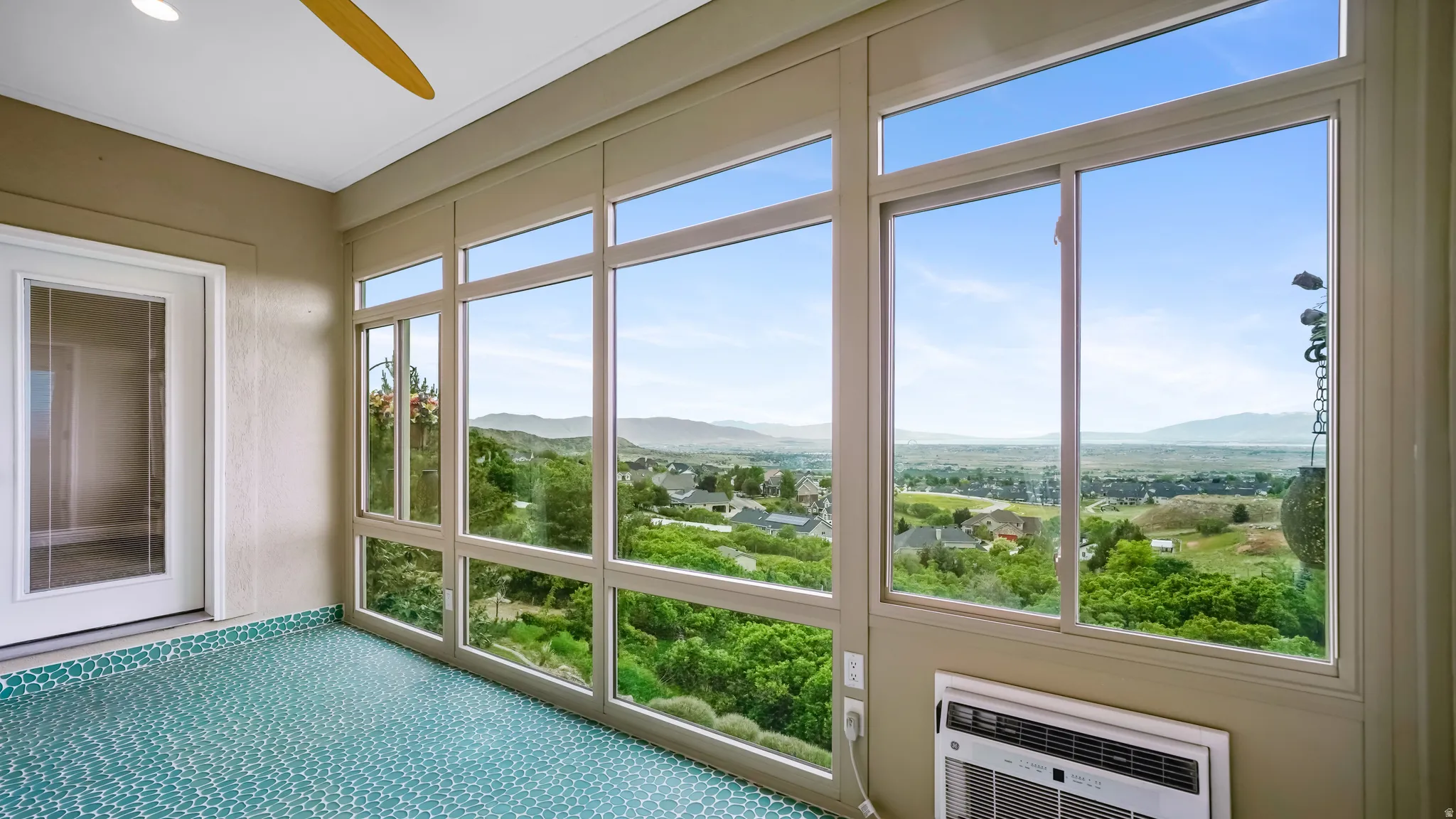 Sunroom featuring floor-to-ceiling windows, a full-lite exterior door, and patterned tile flooring