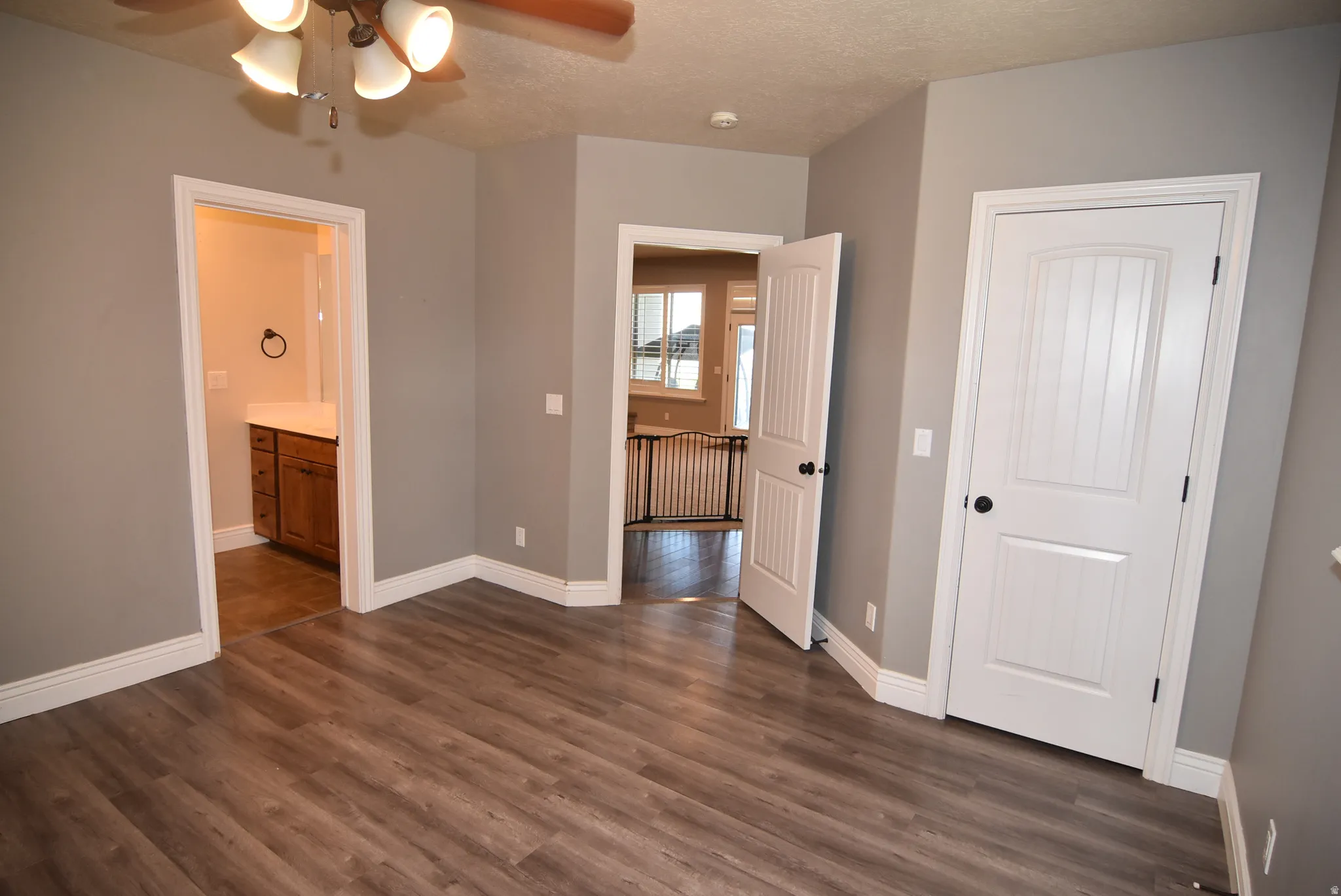 Spacious room featuring wood-finish flooring and neutral gray walls
