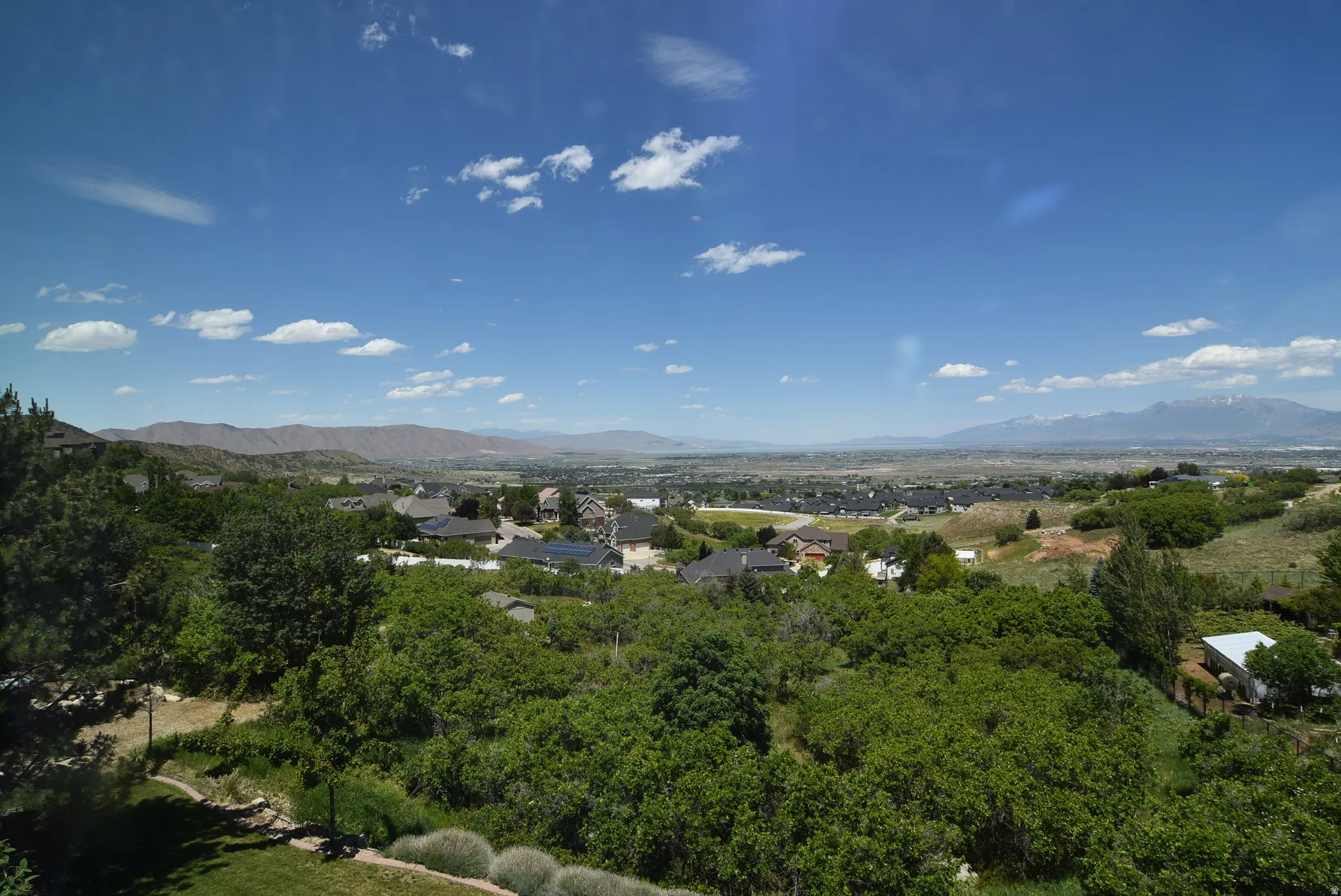 Expansive overhead landscape encompassing a valley, distant mountains, and a residential community