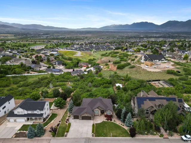 Expansive residential area featuring a variety of architectural styles, mature landscaping, and mountainous terrain in the distance