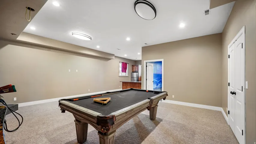 Expansive recreation space featuring recessed lighting, neutral wall tones, and light-toned carpeting