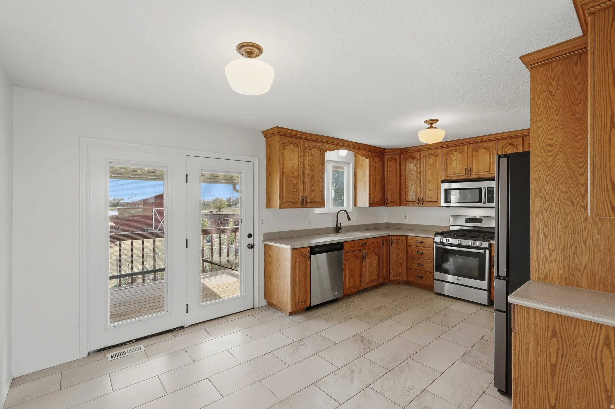 Kitchen featuring wood-finish cabinetry, stainless steel appliances, and light-toned countertops
