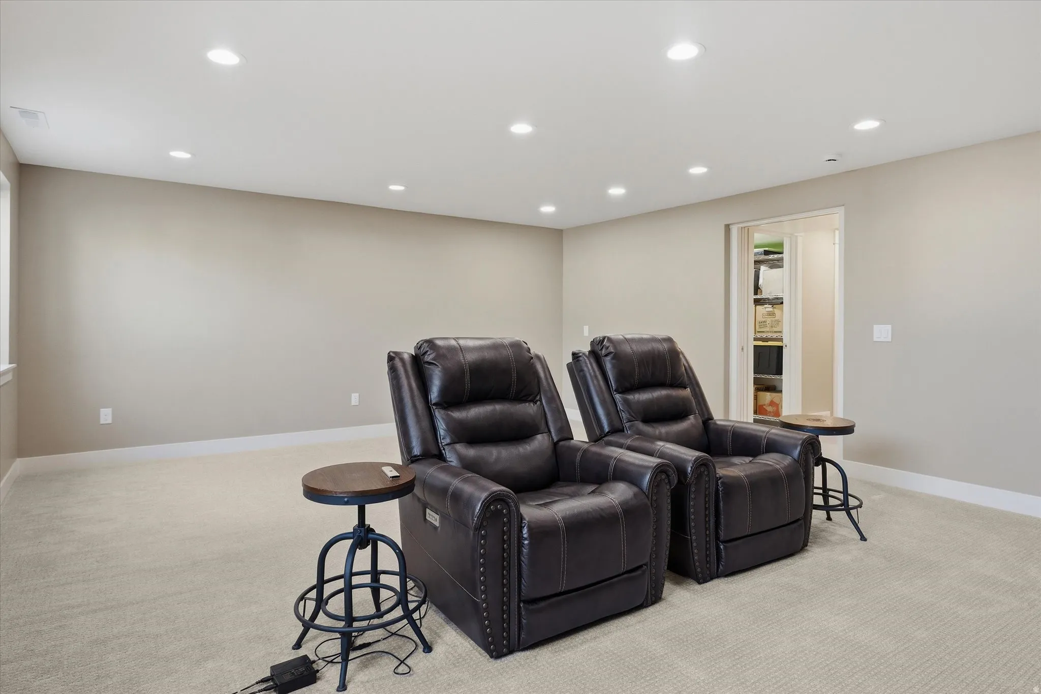 Spacious room featuring neutral carpeting, recessed ceiling lighting, and a window for natural light
